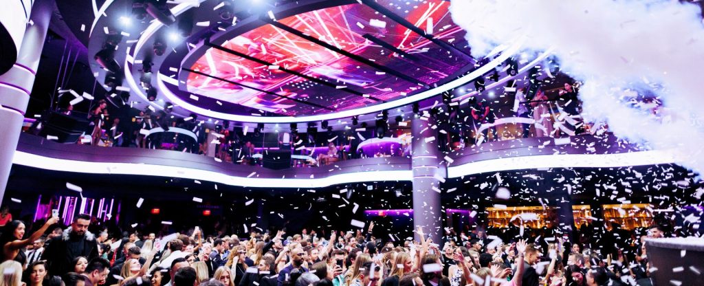 LIV night club lit up by white LED with confetti and smoke being shot over excited crowd